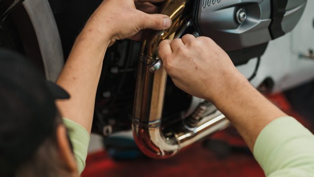 Man fixing a motorcycle in a modern workshop